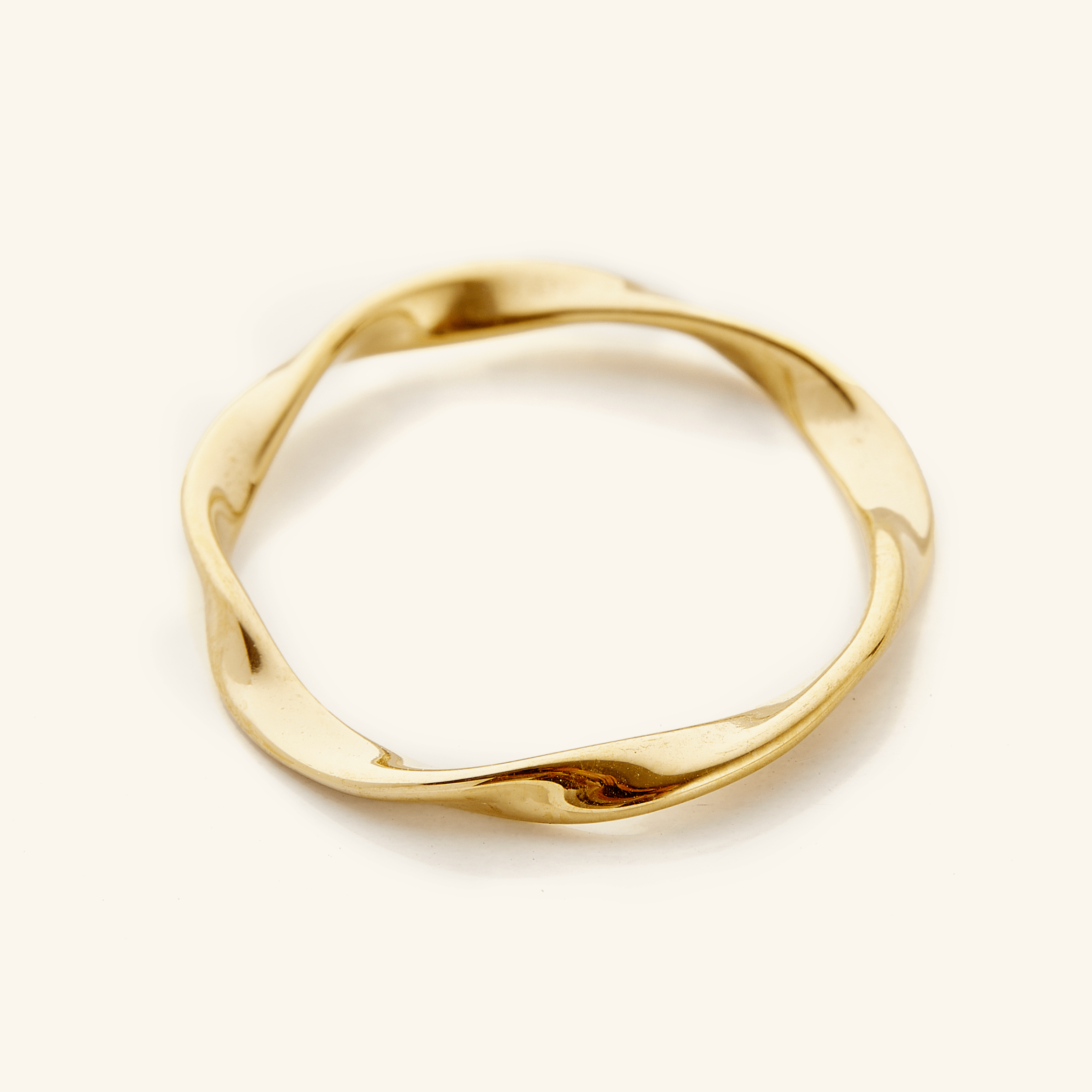 Gold ripple ring displayed on a light background.
