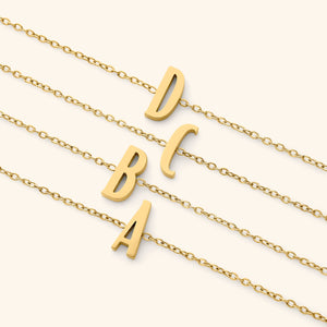 Gold bracelets with english letter pendants on a white background
