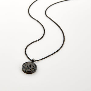 Black necklace with a circular pendant engraved with 'Alhamdulillah' calligraphy, displayed on a white background