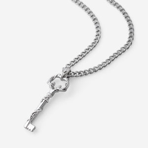 Stainless steel necklace with a detailed key-shaped pendant symbolizing the Palestinian Key of Return, shown against a neutral background. The pendant features sculpted vine-like details and hangs from a thick Cuban-style chain.
