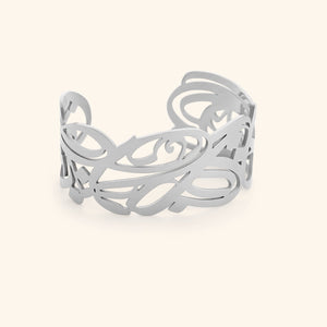 A silver cuff bracelet with intricate, swirling cut-out designs. The bracelet is wide and open-ended, and the delicate patterns create a lacy or filigree effect. The text "GRACE (Cuff) | Aadil x Nominal" indicates this is a product shot of the "Grace" cuff bracelet, a collaboration between Aadil and Nominal.