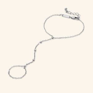 Close-up of the Diamond Path Hand Chain in polished silver, showing the delicate chain with five bezel-set 3mm cubic zirconia stones, designed to connect a ring to the wrist.