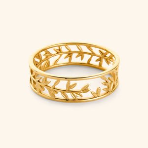 Gold Eternal bangle featuring olive leaves pattern against light background