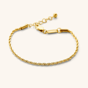 Flat lay of the 18k gold plated essential rope bracelet that features a woven chain pattern.