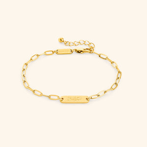 Gold Sakinah Serenity link bracelet showing the Arabic engraving on center tag, photographed against a light background.