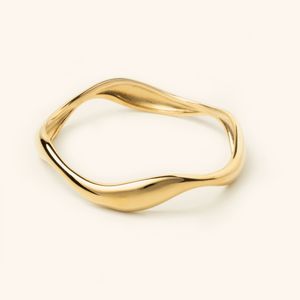 Photo of an 18k gold plated Wave Bangle features cascading curves to remind you that life ebbs and flows.