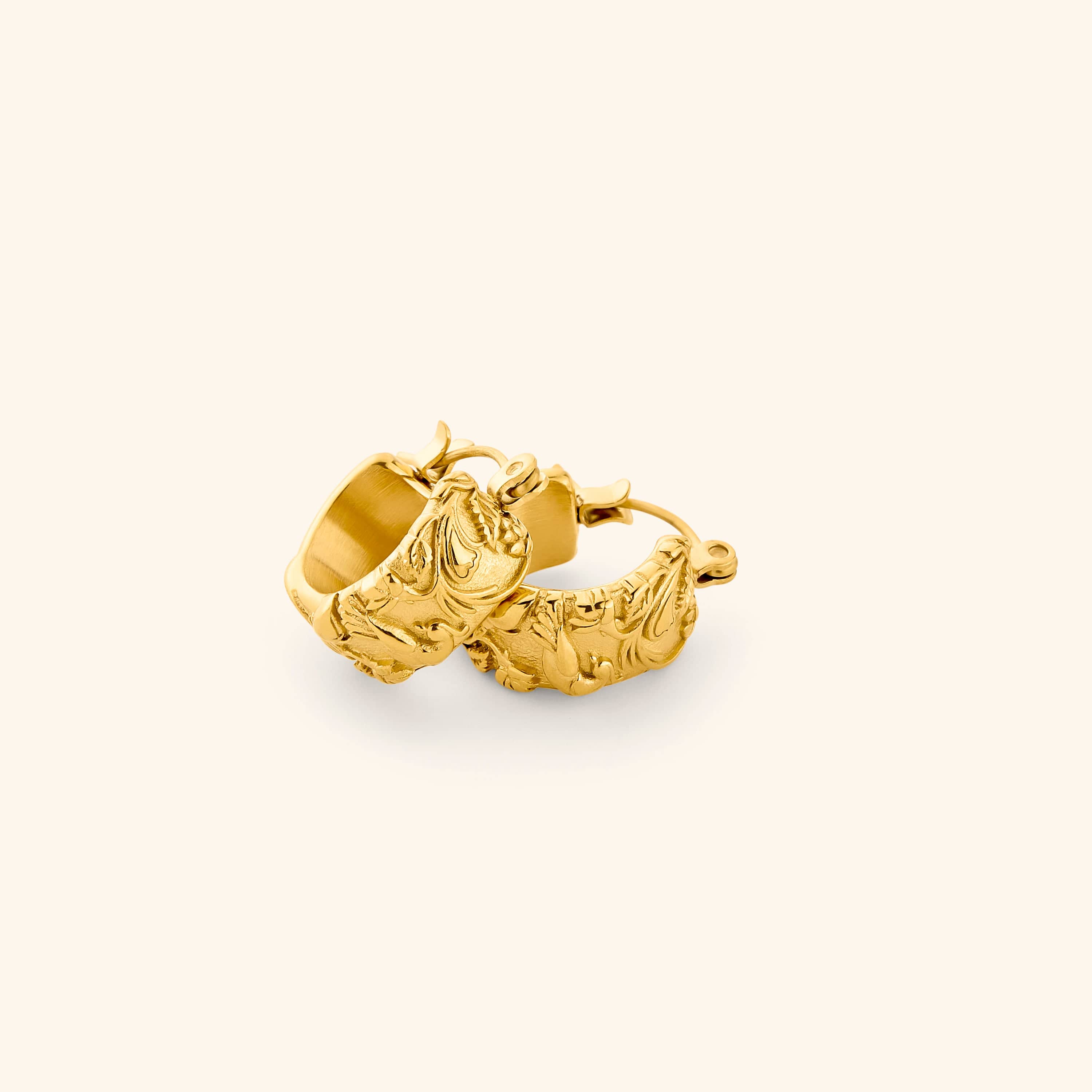 A pair of 18k gold thick hoop earrings wrapped in jasmine, marigolds, and water lilies across the entire surface