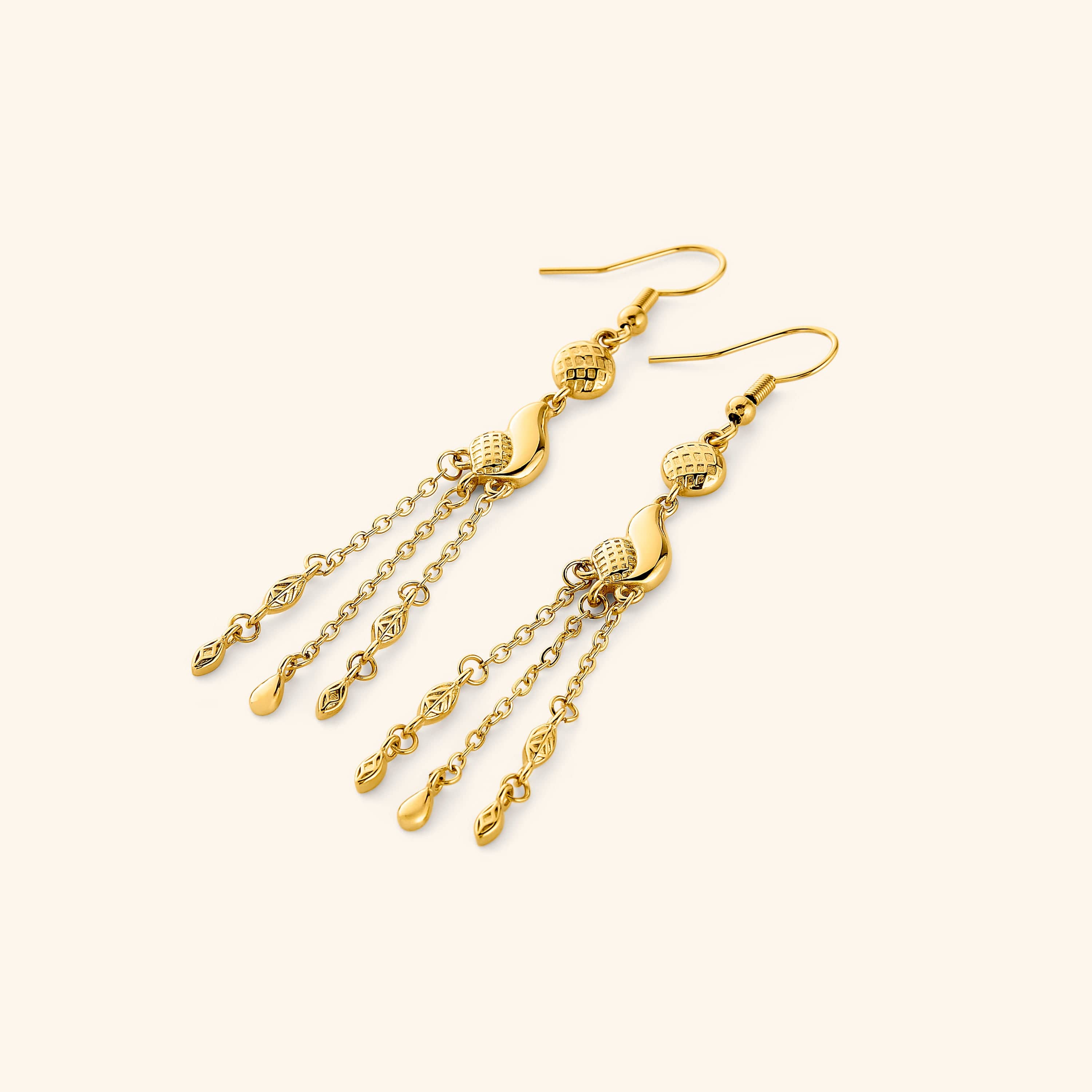 A pair of 18k gold plated earrings that features paisley droplets suspended from textured coins, each one trailing three delicate chains that move when you do.