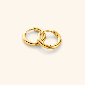 Flat lay of the 18k gold plated Huggie Essential Hoops | 8mm against a white background.