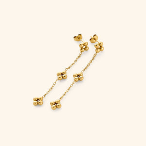 Close-up of the Dangling Henna Earrings in gold with bead clusters linked by a delicate chain.