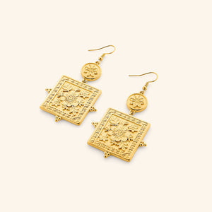 Pair of gold Mehndi Floral Earrings featuring engraved floral square pendants and small round floral charm with hook backs.