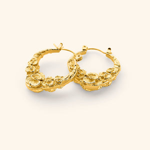 A pair of 18k gold plated hoop earrings that feature sculpted poppy flower design.