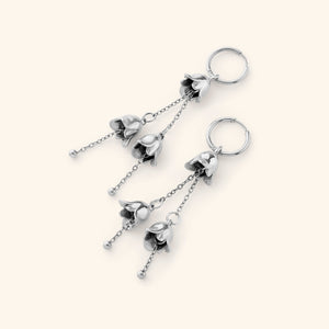 A pair of Raining Tulip Hoops in silver, showcasing the same floral-inspired dangling design on fine chains attached to hoops.