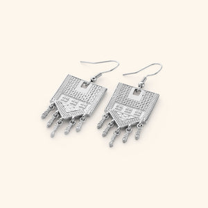 Pair of silver statement earrings carved with motifs of tatreez.