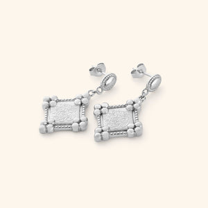 Silver earrings featuring Diamond-shaped plaques stamped with حَسْبُنَا اللَّهُ وَنِعْمَ الْوَكِيلُ (Hasbunallahu wa ni'mal wakeel).