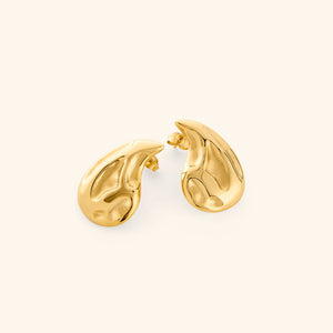 Pair of gold earrings shaped like a droplet, shot on a white background