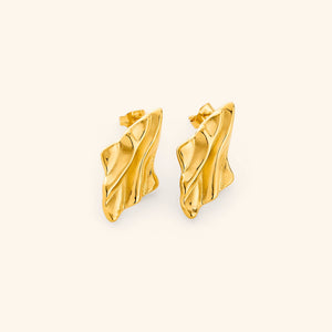 Gold earrings with a melted design appearance, on a white background