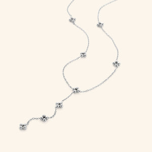 Close-up of the Henna Lariat Necklace in silver, featuring delicate chain links with small clustered bead accents and a drop lariat design.