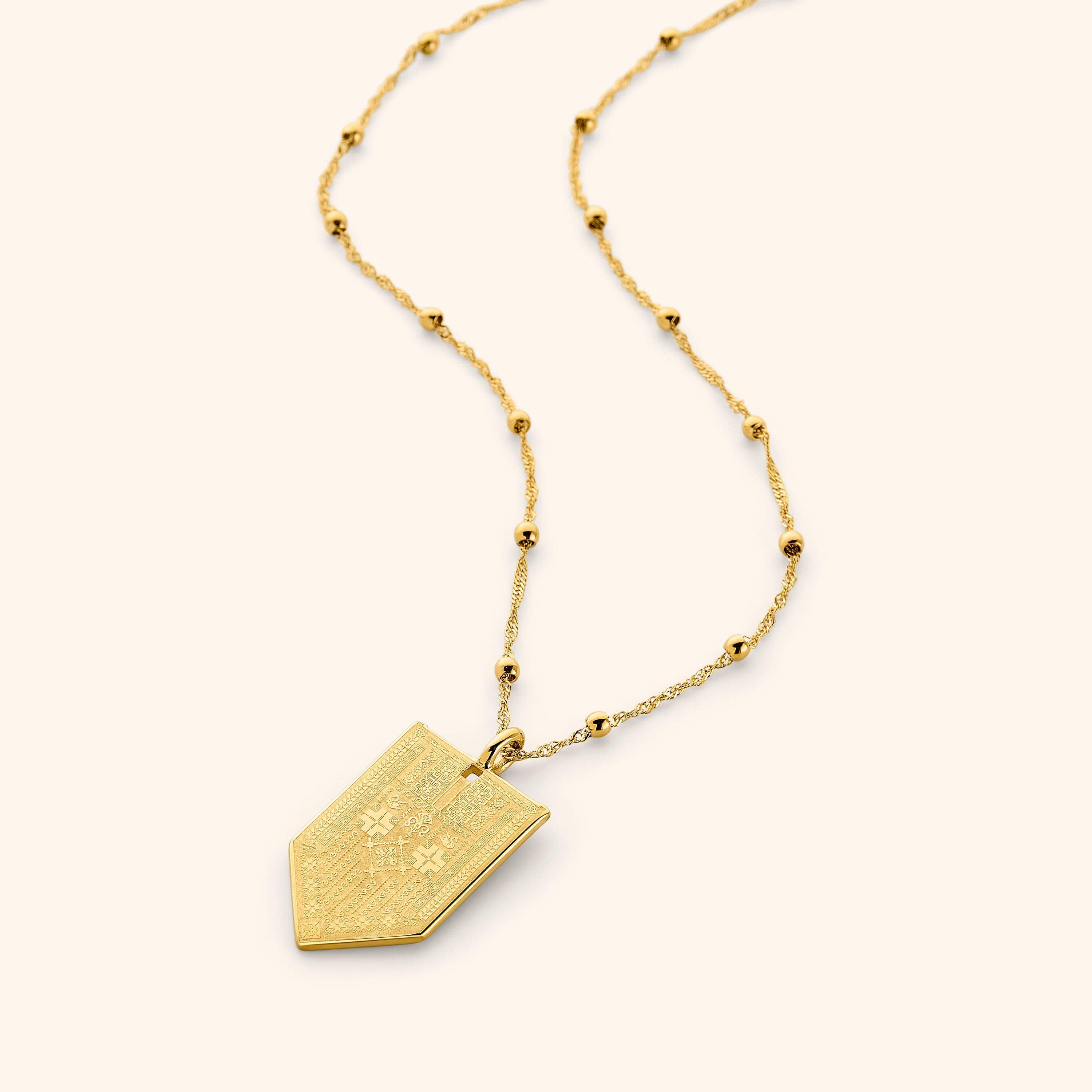 Necklace with 18K gold plated pointed tag pendant with design inspired by Tatreez on a dotted 18K Gold plated chain.