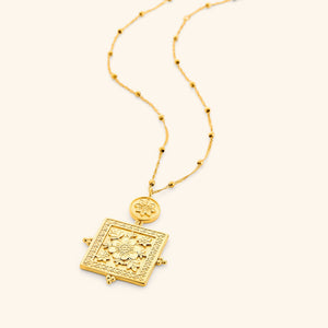 Mehndi Floral Necklace featuring a gold square pendant with engraved floral patterns and a smaller round floral charm on a beaded chain.