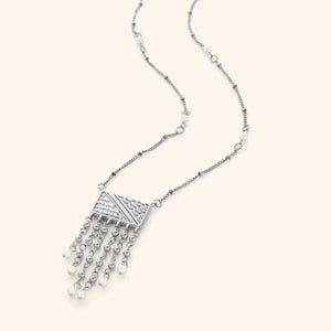Silver necklace featuring a rectangular plate that is engraved with the patterns of the Palestinian keffiyeh, and then trailed with chains that are finished with pearl orbs. The necklace is finished with pearl orbs along the chain.
