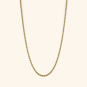Gold rope chain necklace displayed on a light cream background