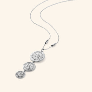 Silver necklace that features three coins stacked and stamped with صبر (patience), hanging from a beaded chain, the coins are kept graduated in size, on a thin chain.