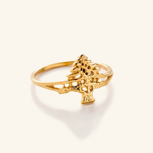 Gold ring featuring a detailed cut-out design of the Cedar of Lebanon tree, with textured branches and an open structure on a slim band, shown against a neutral background.