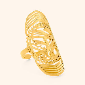 Close-up of a gold Sufficient ring featuring intricate Arabic calligraphy cutout design, photographed against a neutral background.