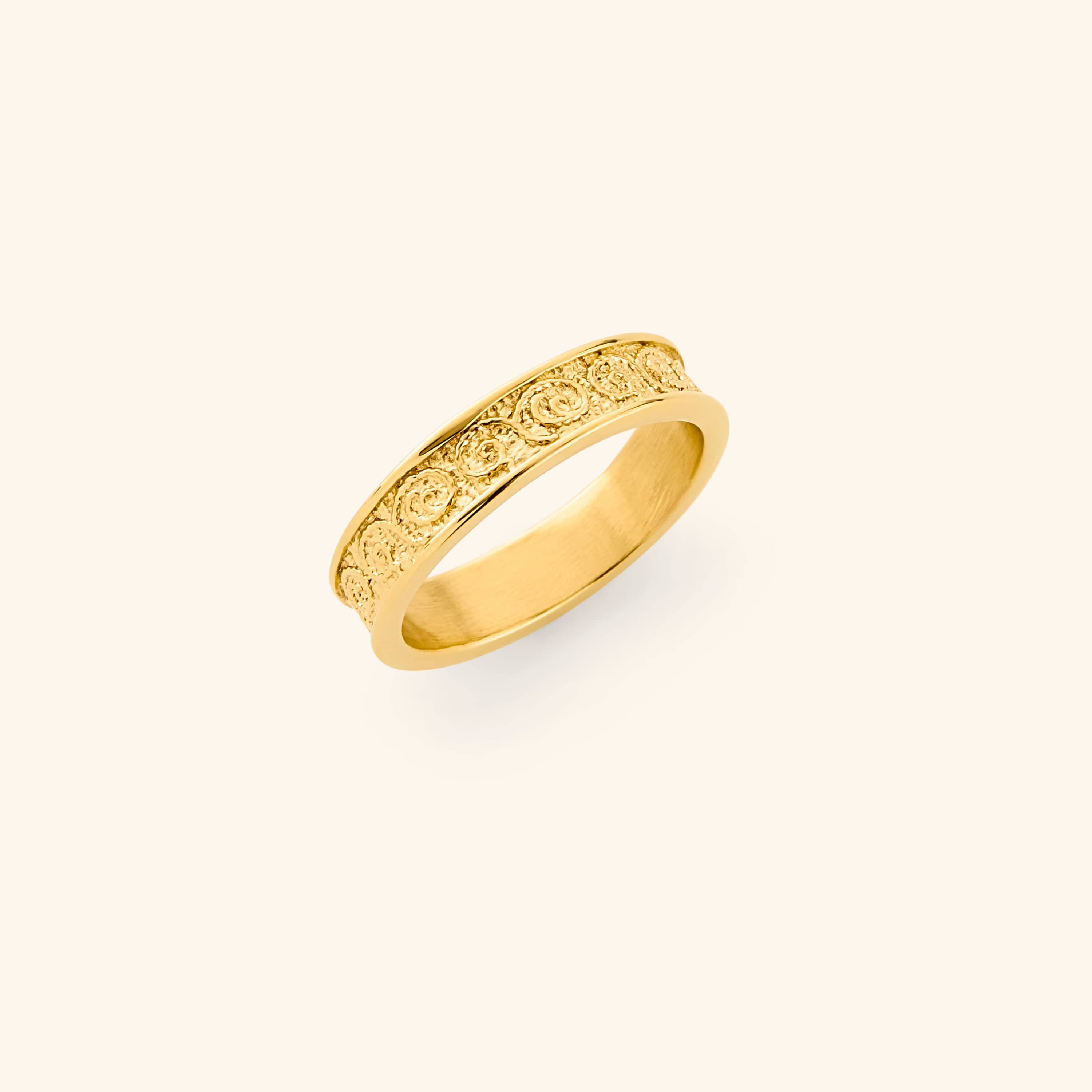 Gold vintage royalty ring with intricate design on a light background