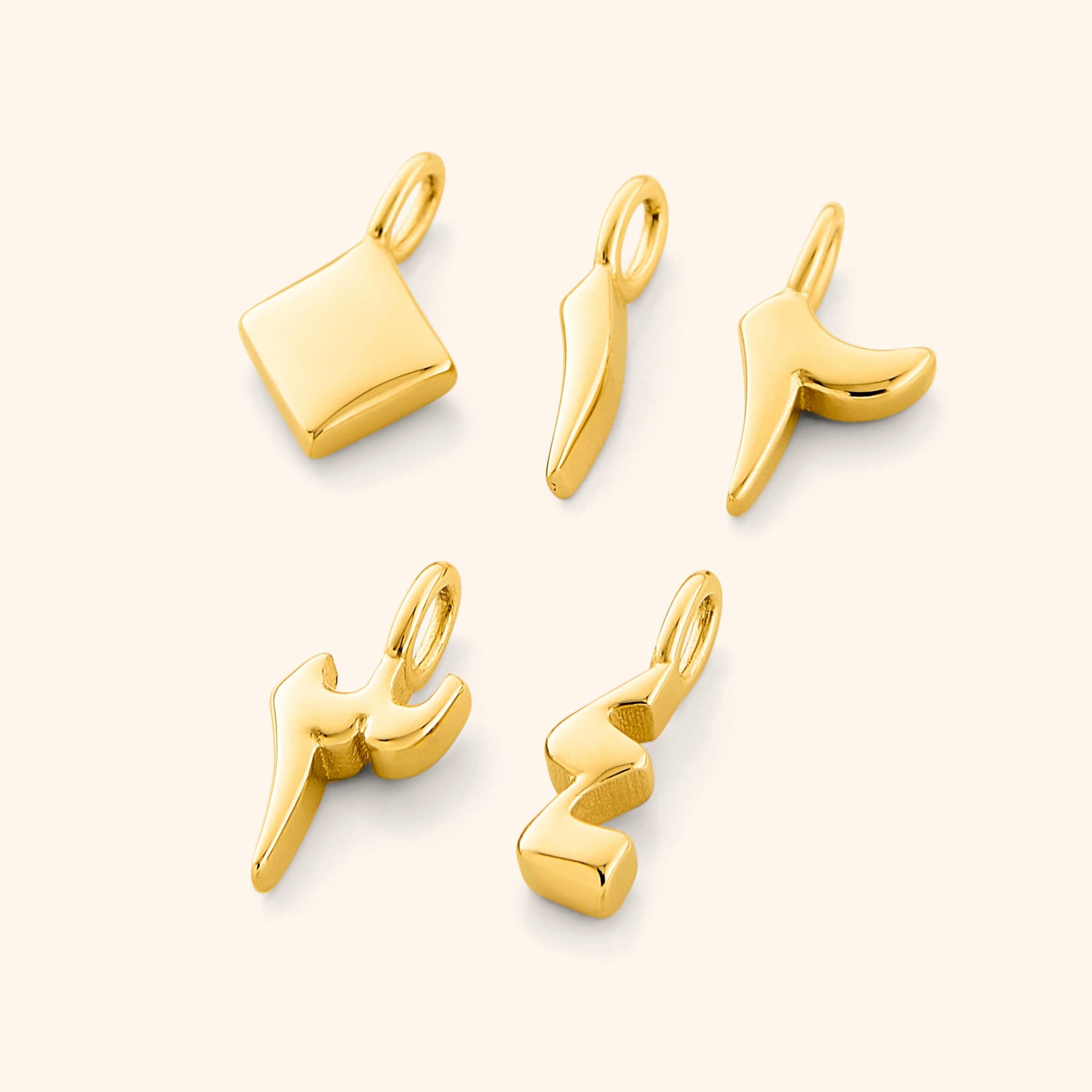 A flat lay of five gold-plated Arabic number charms on a white background, each charm featuring an iridescent pearl backdrop with the numbers 0, 1, 2, 3, and 4 engraved in Arabic numerals.