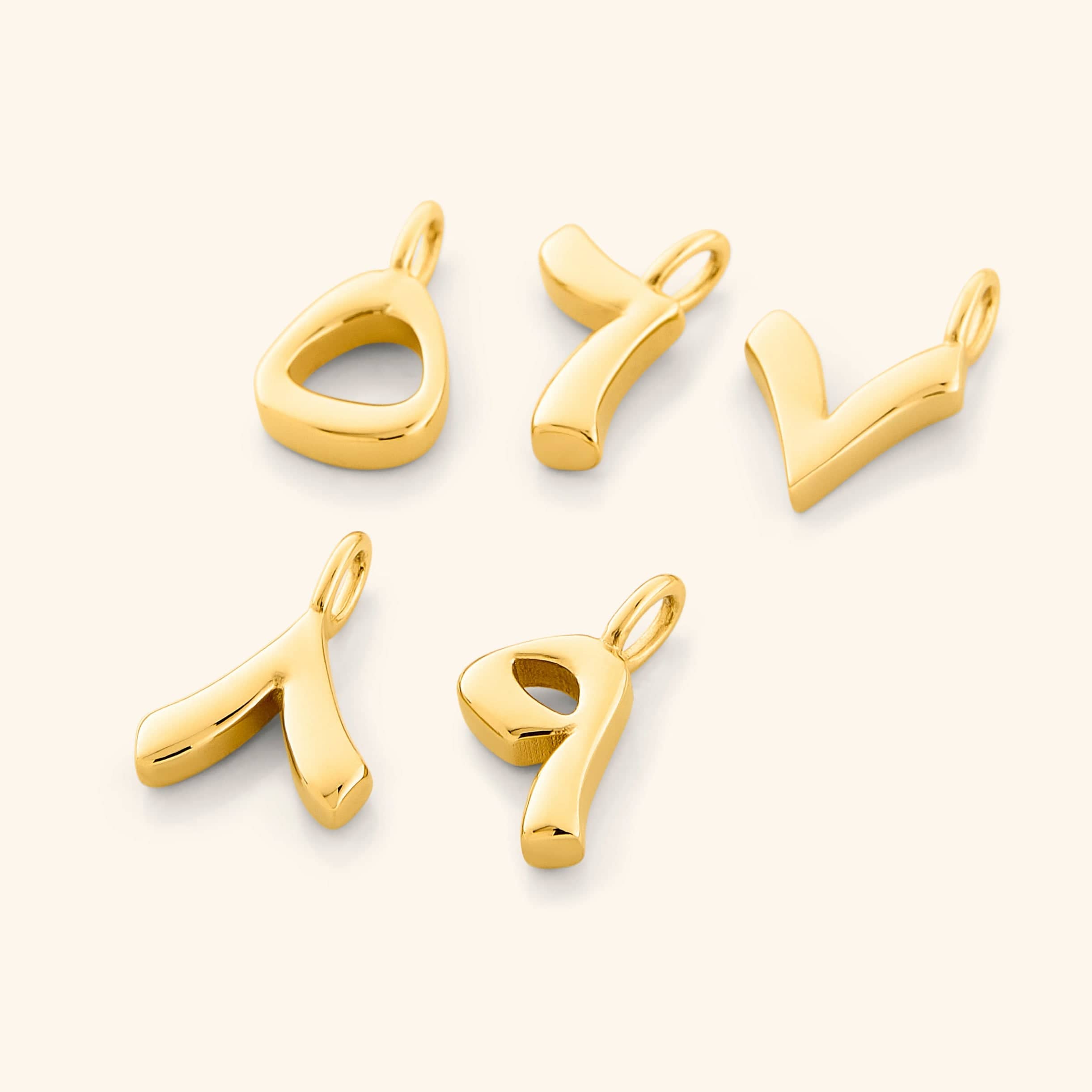 A flat lay of five gold-plated Arabic number charms on a white background, each charm featuring an iridescent pearl backdrop with the numbers 5, 6, 7, 8, and 9 engraved in Arabic numerals.