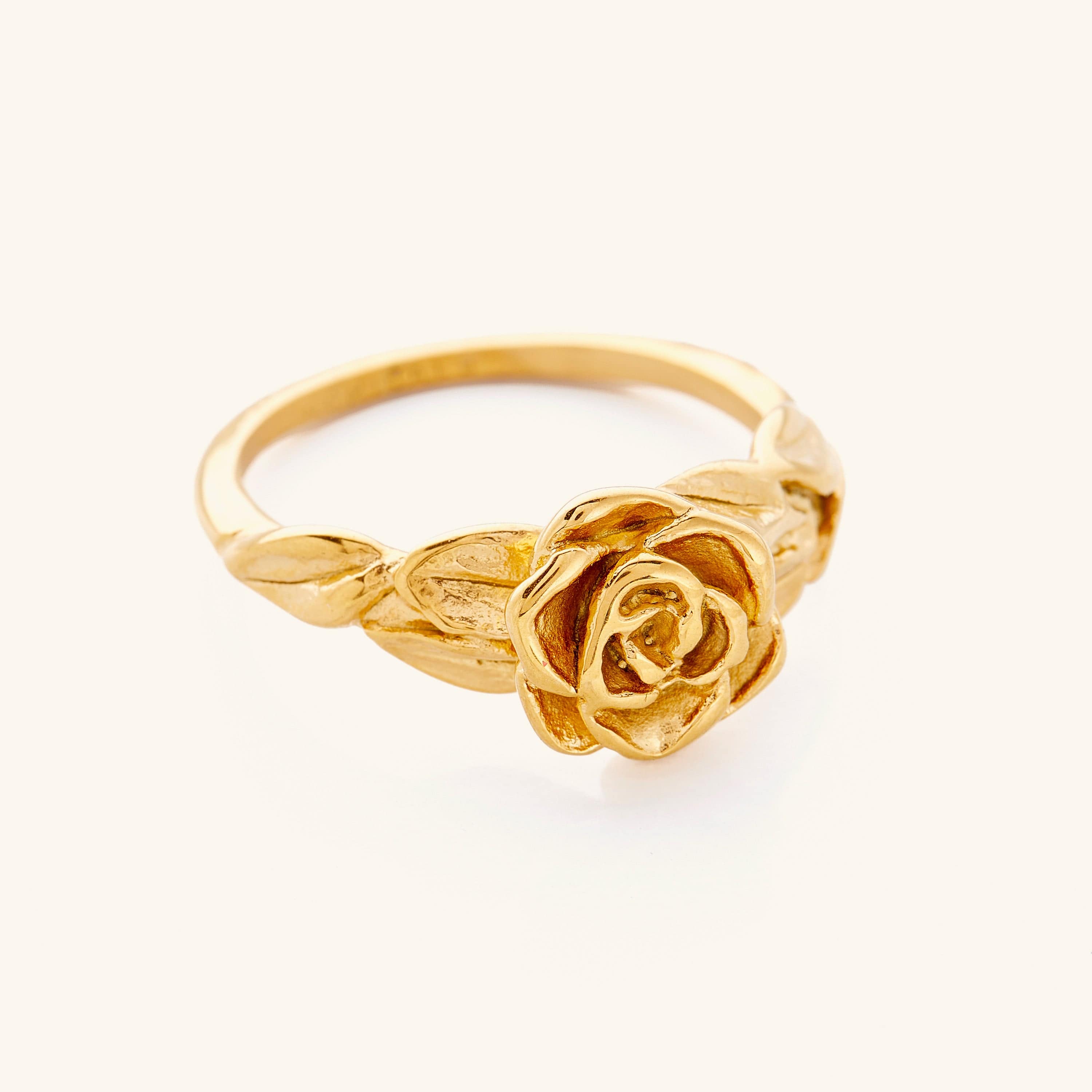 Gold ring featuring a detailed rose design with textured petals and leaves along the band.