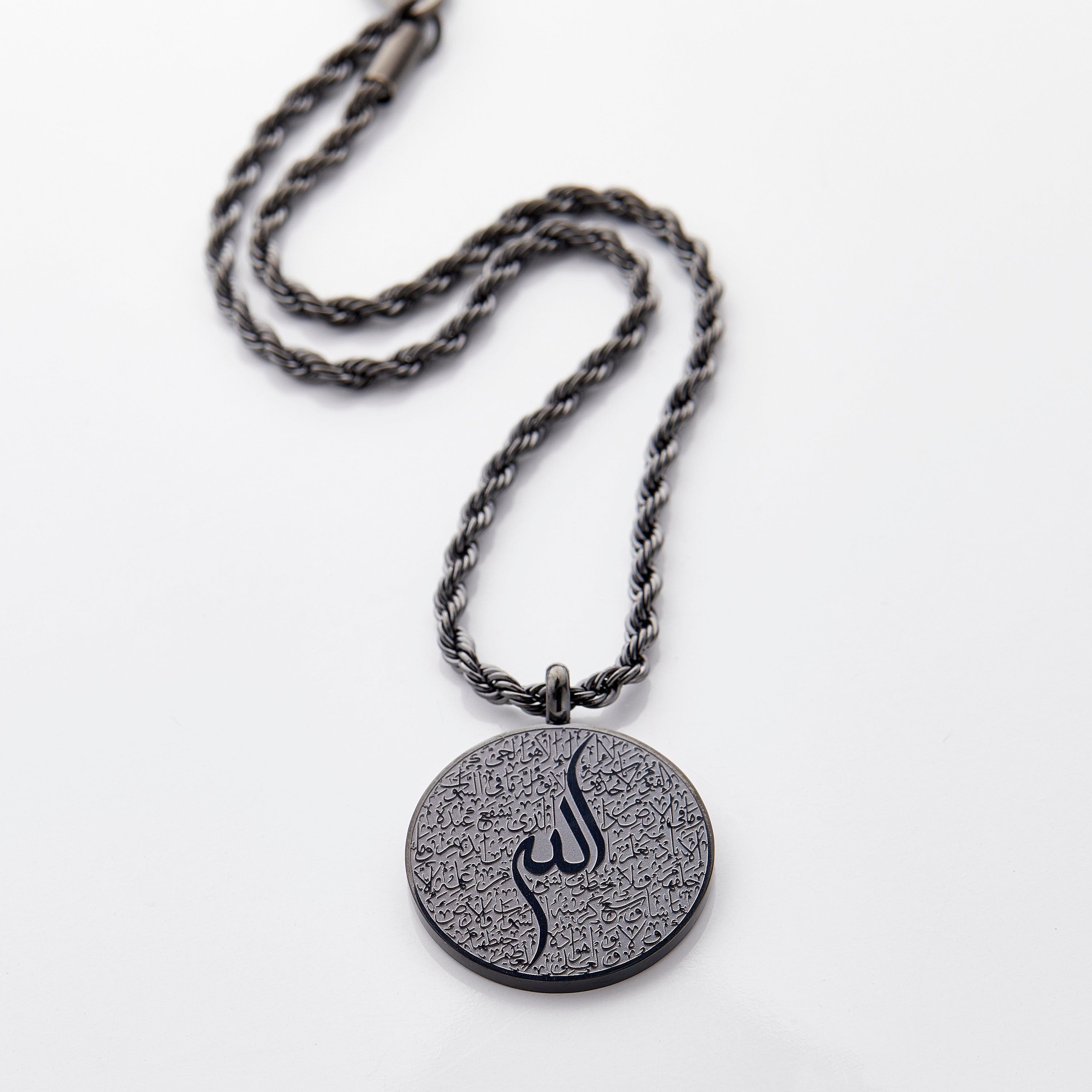 Black car hanger with a circular pendant engraved in Arabic calligraphy of Ayatul Kursi, styled flat on a neutral background.