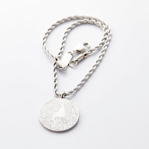 Silver car hanger with a circular pendant engraved in Arabic calligraphy of Ayatul Kursi, styled flat against a neutral background.