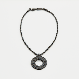 Black car hanger with a circular pendant engraved in Arabic calligraphy reading “With Hardship Comes Ease,” displayed against a neutral background.