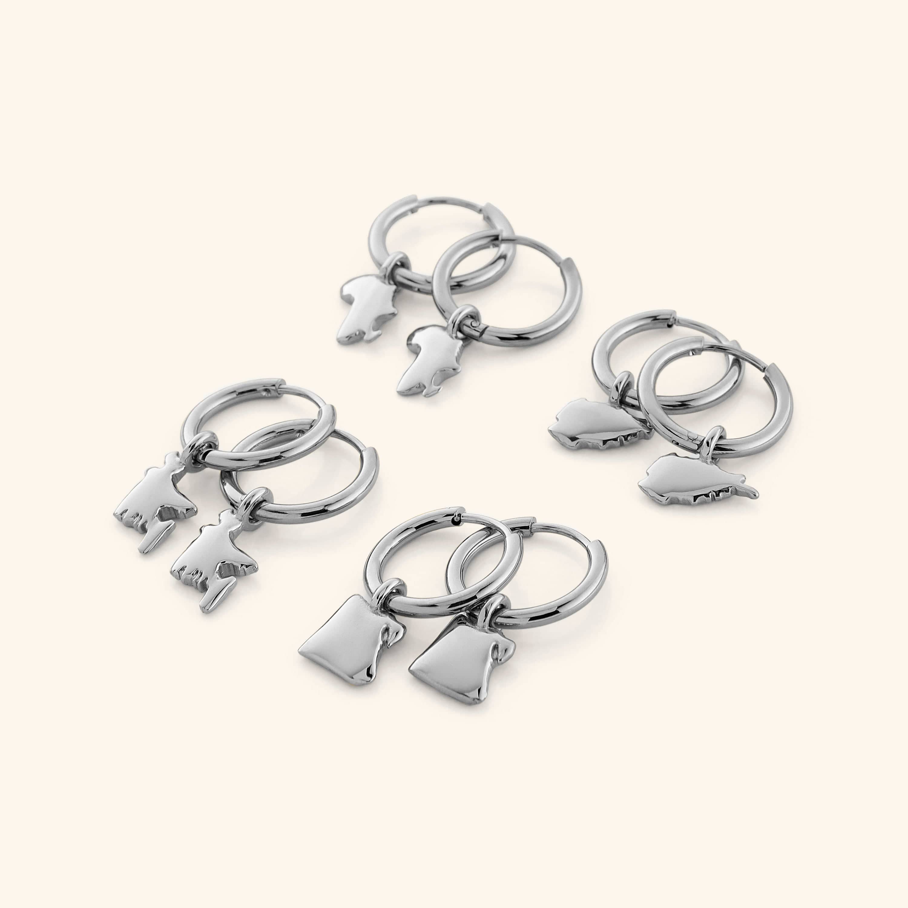 4 different pairs of silver hoop earrings that features outlines of different countries.
