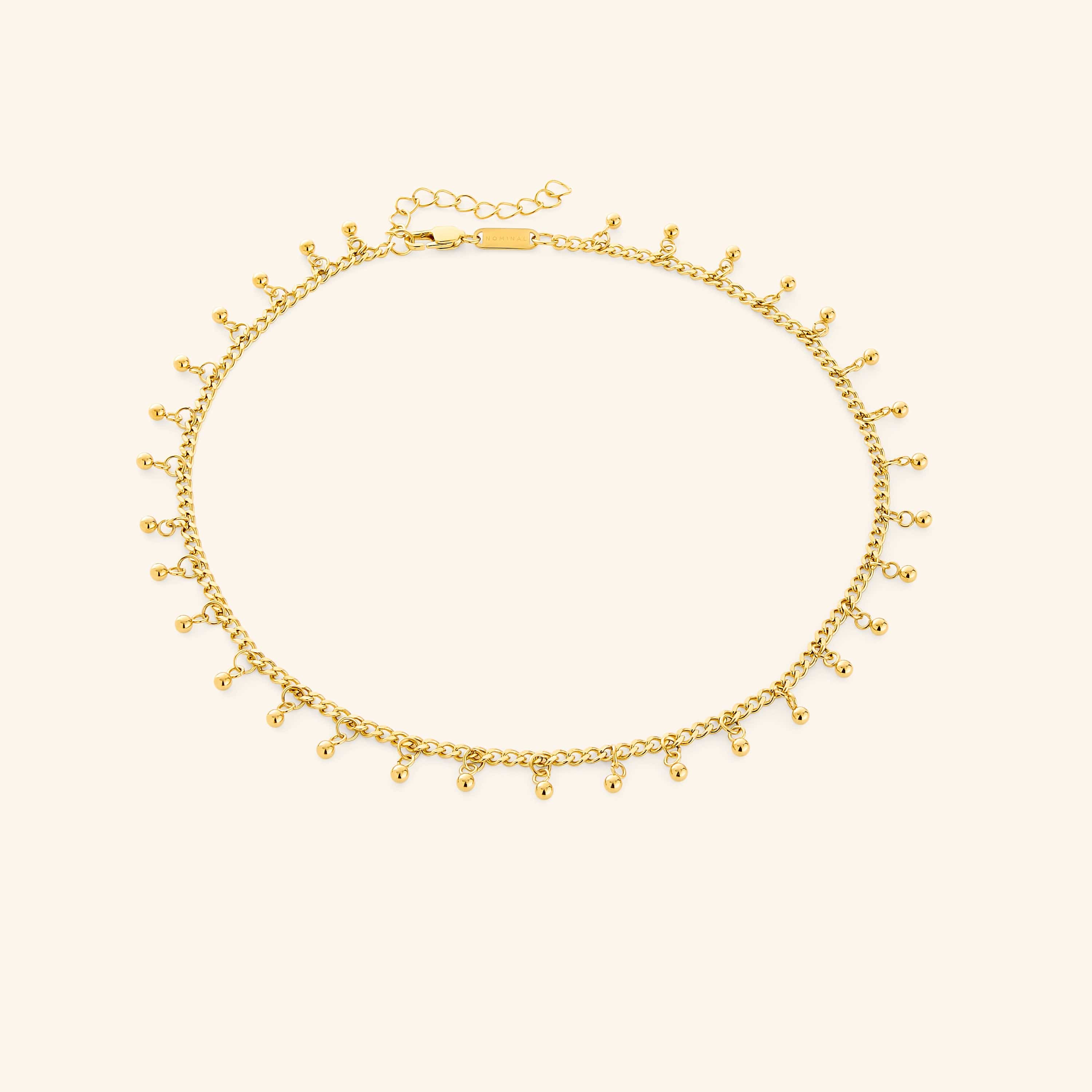 A close-up of the Dangling Dotted Choker in 18K gold plating. The choker features a delicate chain with evenly spaced 3mm spherical bead accents that dangle, creating a subtle and elegant design.