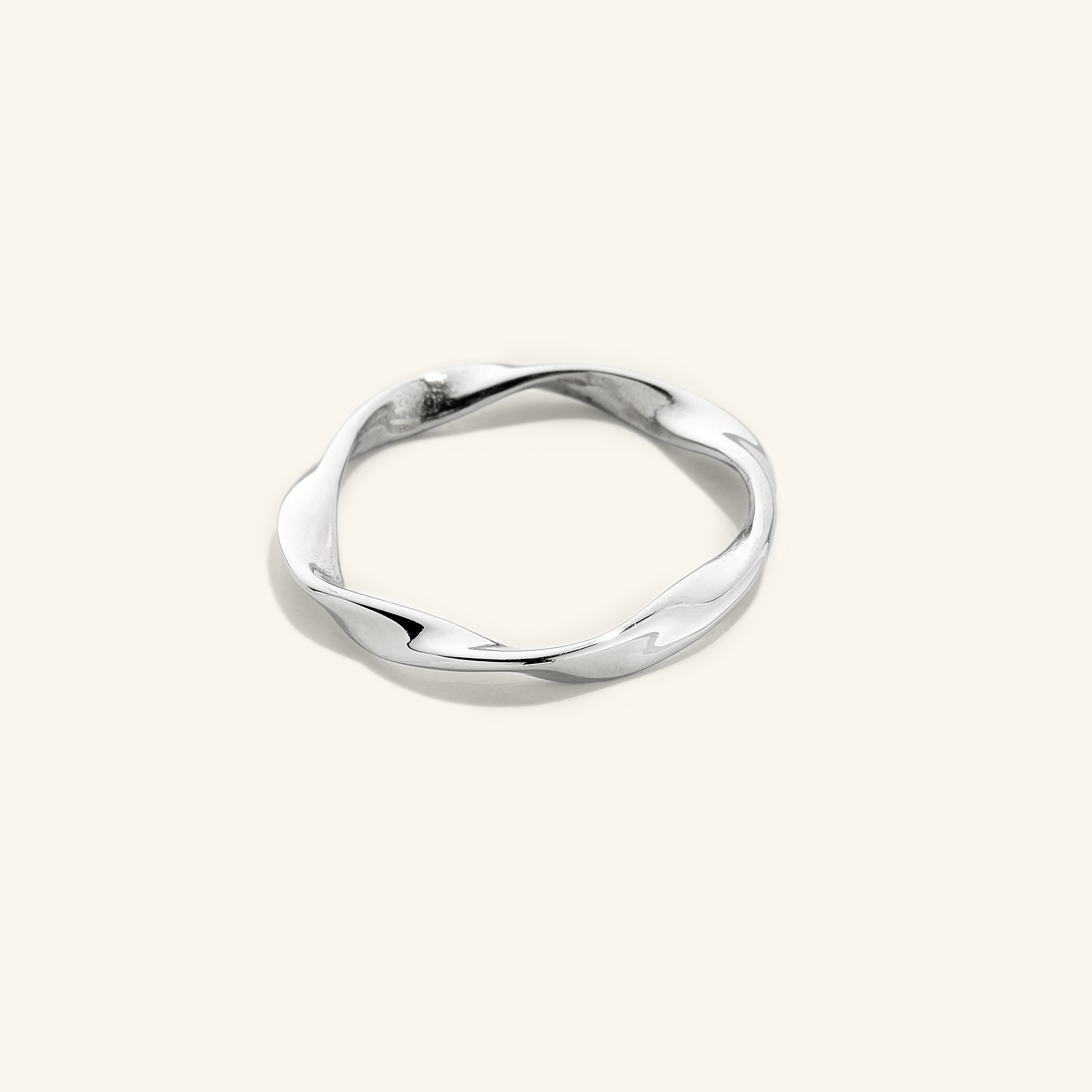 Silver ripple ring, displayed on a light surface.