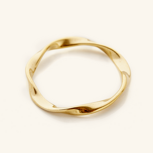 Gold ripple ring displayed on a light background.