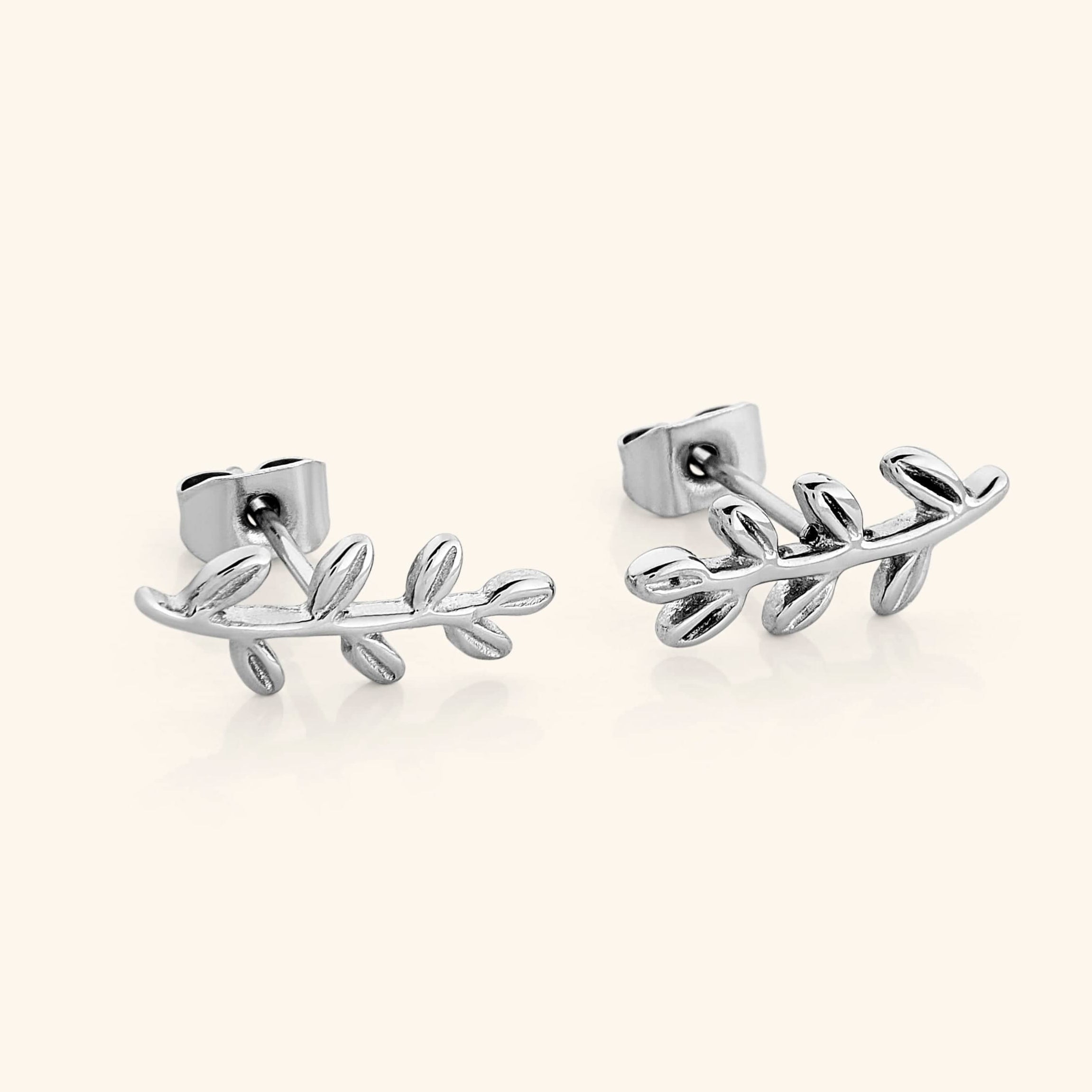 The Olive Leaf Earrings in a polished silver finish, showcasing intricate olive leaf motifs. The earrings are crafted from hypoallergenic stainless steel, offering a sleek and timeless appearance.