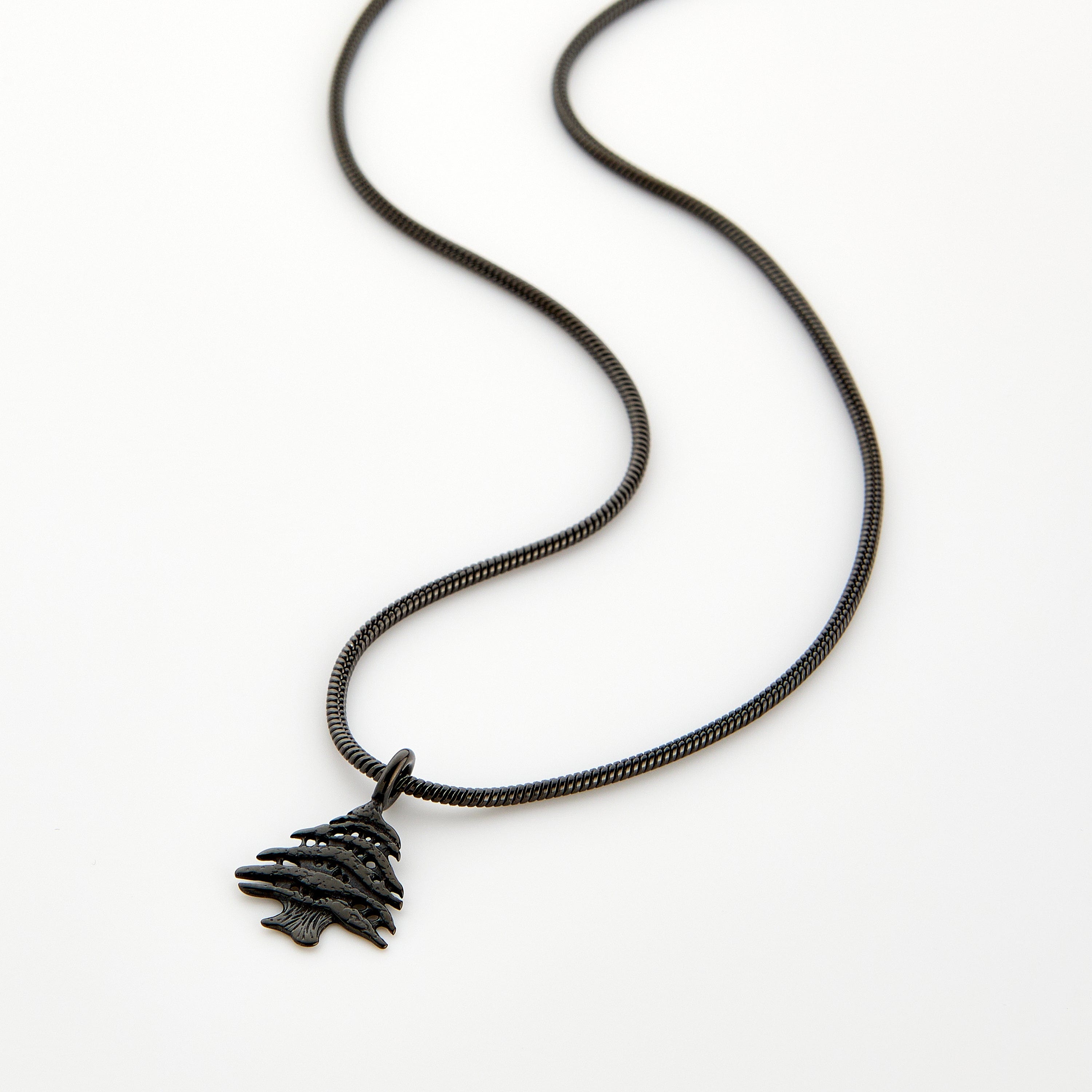 Black necklace with a Cedar of Lebanon tree pendant, displayed on a white background.