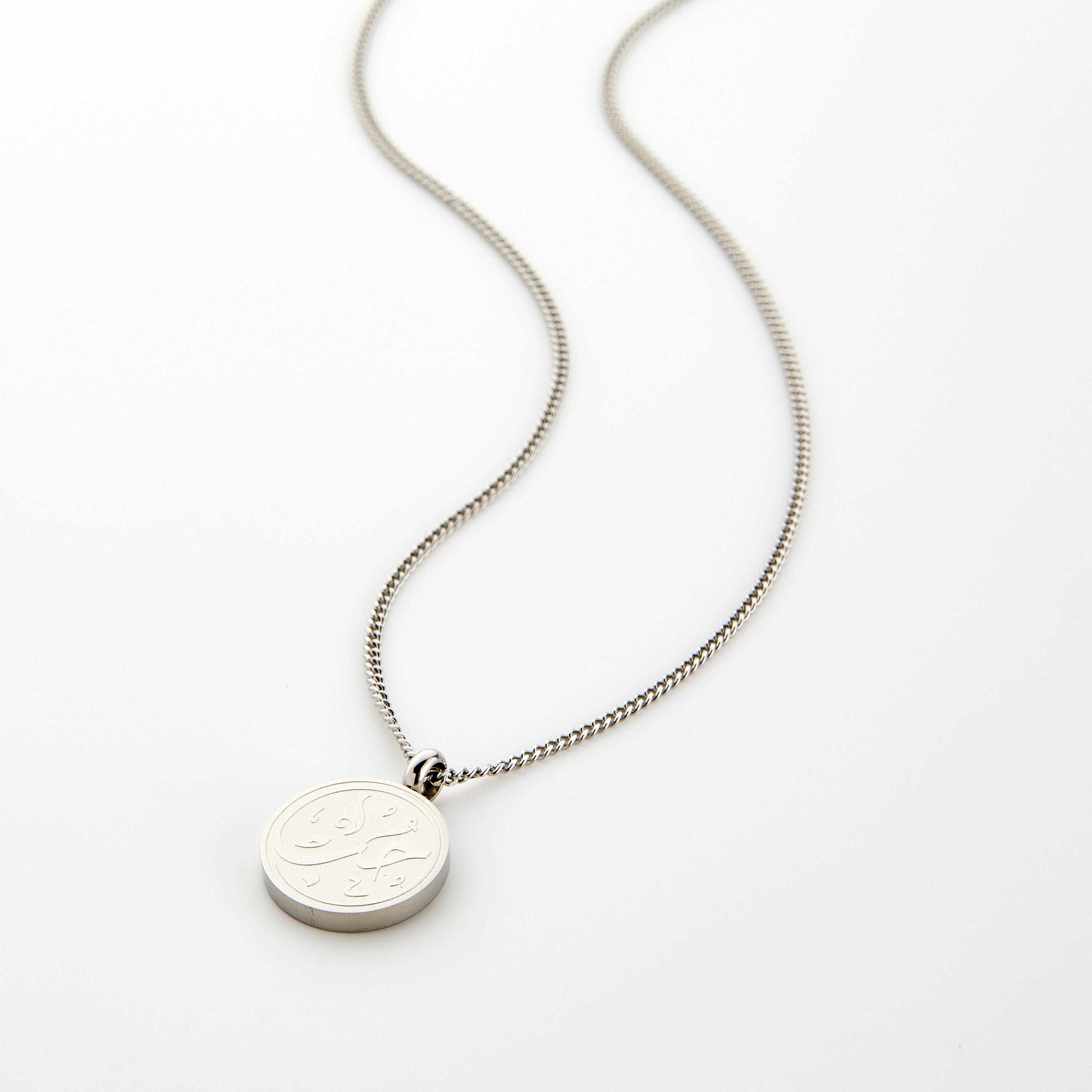 Silver necklace with a circular pendant engraved with 'Hub' calligraphy, displayed on a white background.