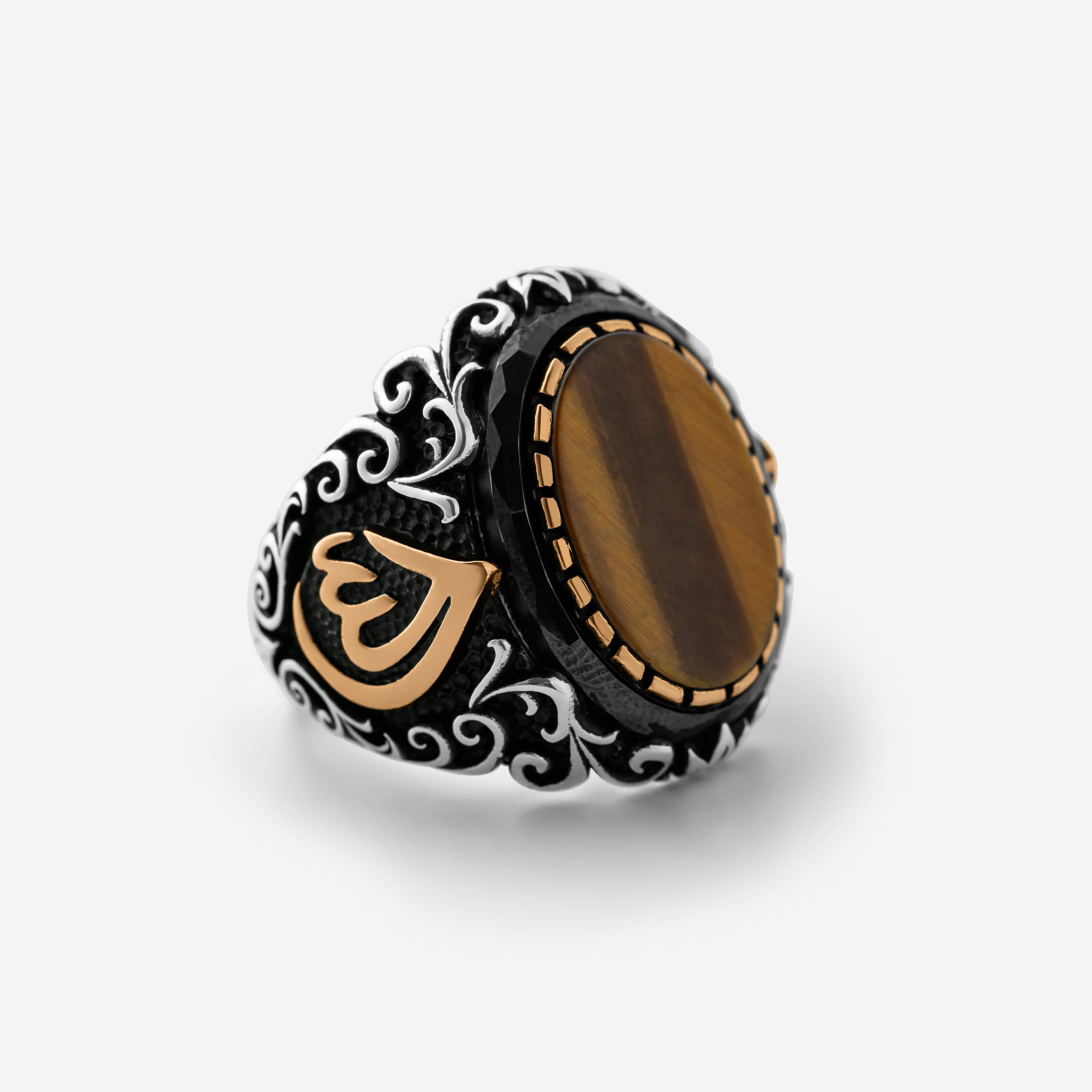 Men’s silver ring with a tiger's eye stone and an Arabic calligraphy detail of the word ‘Allah,’ surrounded by ornate black and silver engravings.