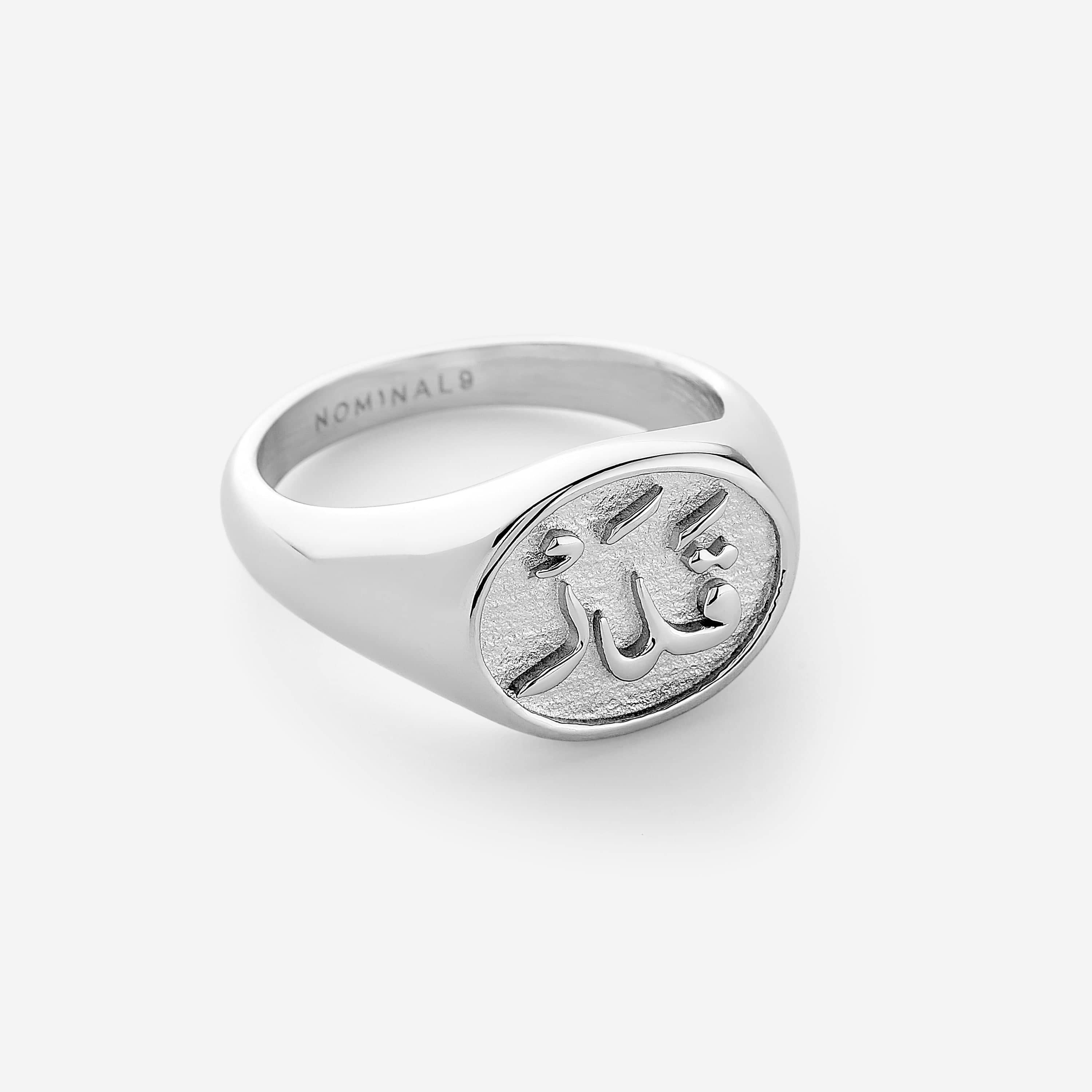 A silver ring embossed with the Arabic word for destiny, قدر,