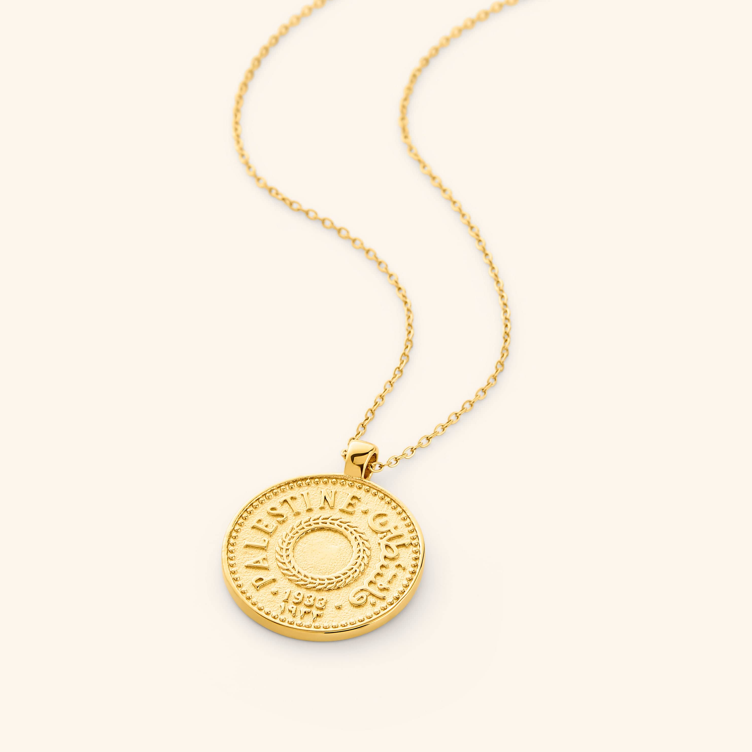 Flat lay of the gold Palestine Coin Necklace.