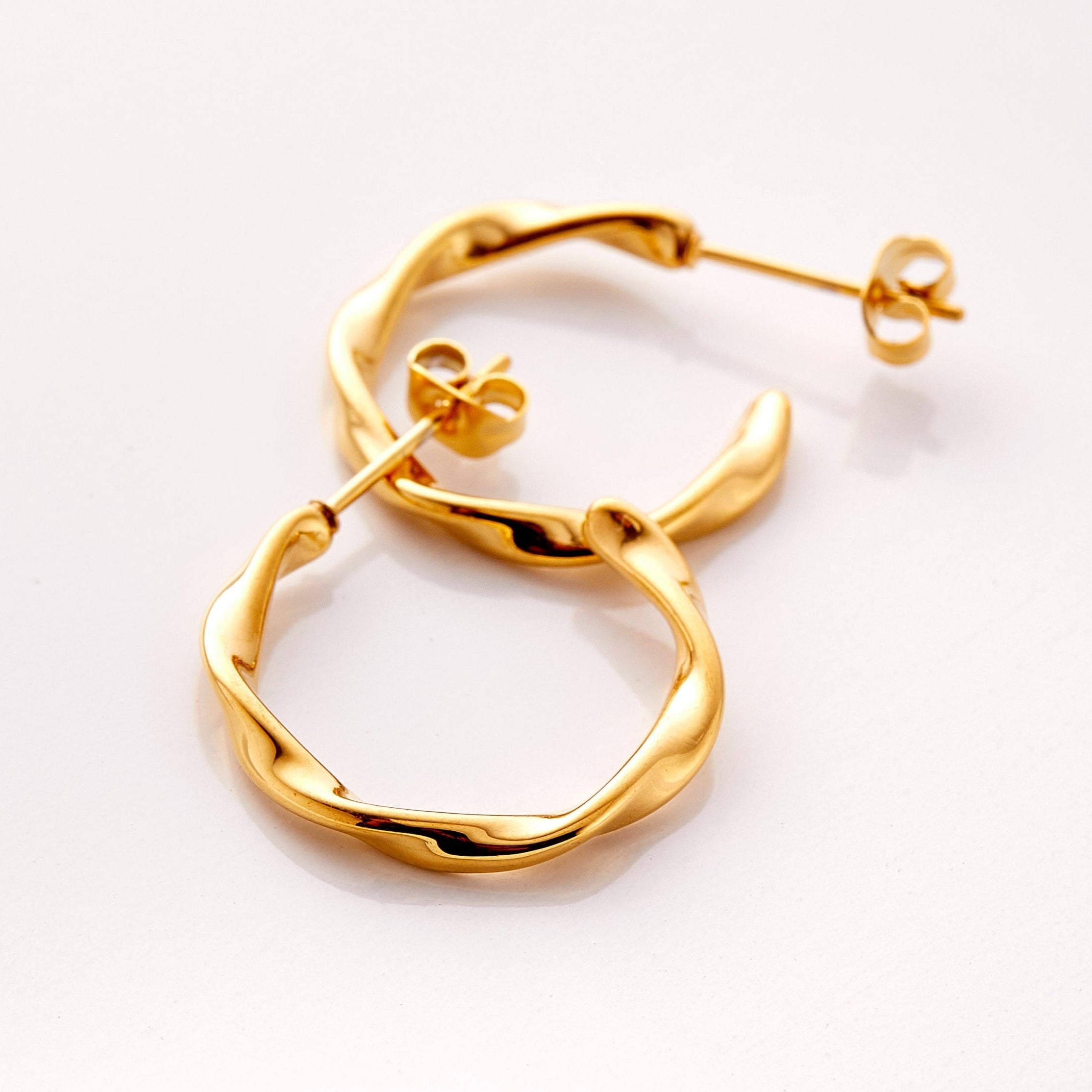 A pair of 18k gold plated hoop earrings. The Ripple Hoop Earrings are inspired by the ripple effect that a pebble can cause in the ocean