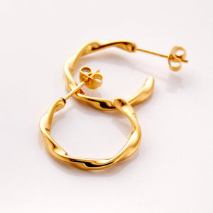 A pair of 18k gold plated hoop earrings. The Ripple Hoop Earrings are inspired by the ripple effect that a pebble can cause in the ocean