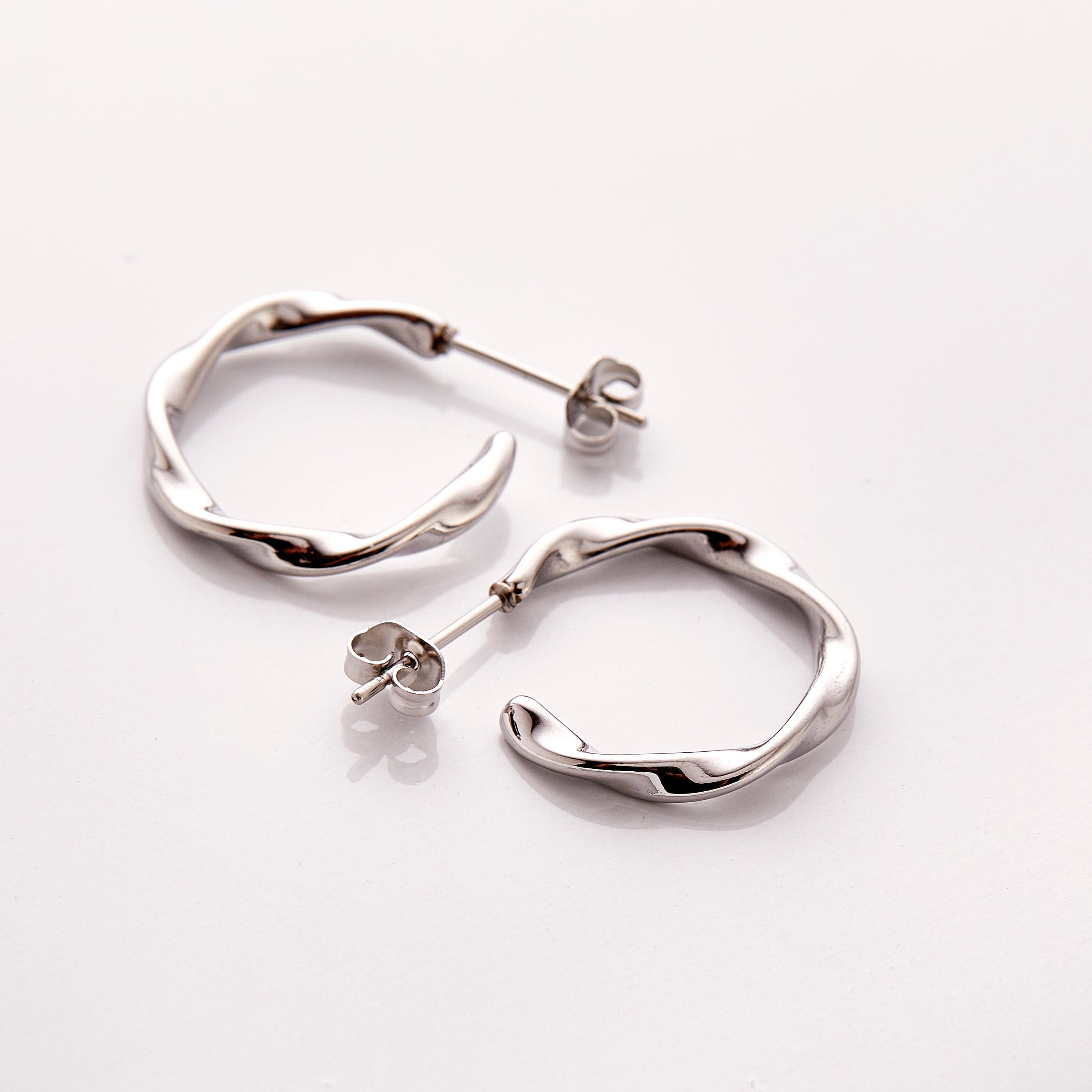 The Silver Ripple Hoop Earrings - Nominal against a white background.