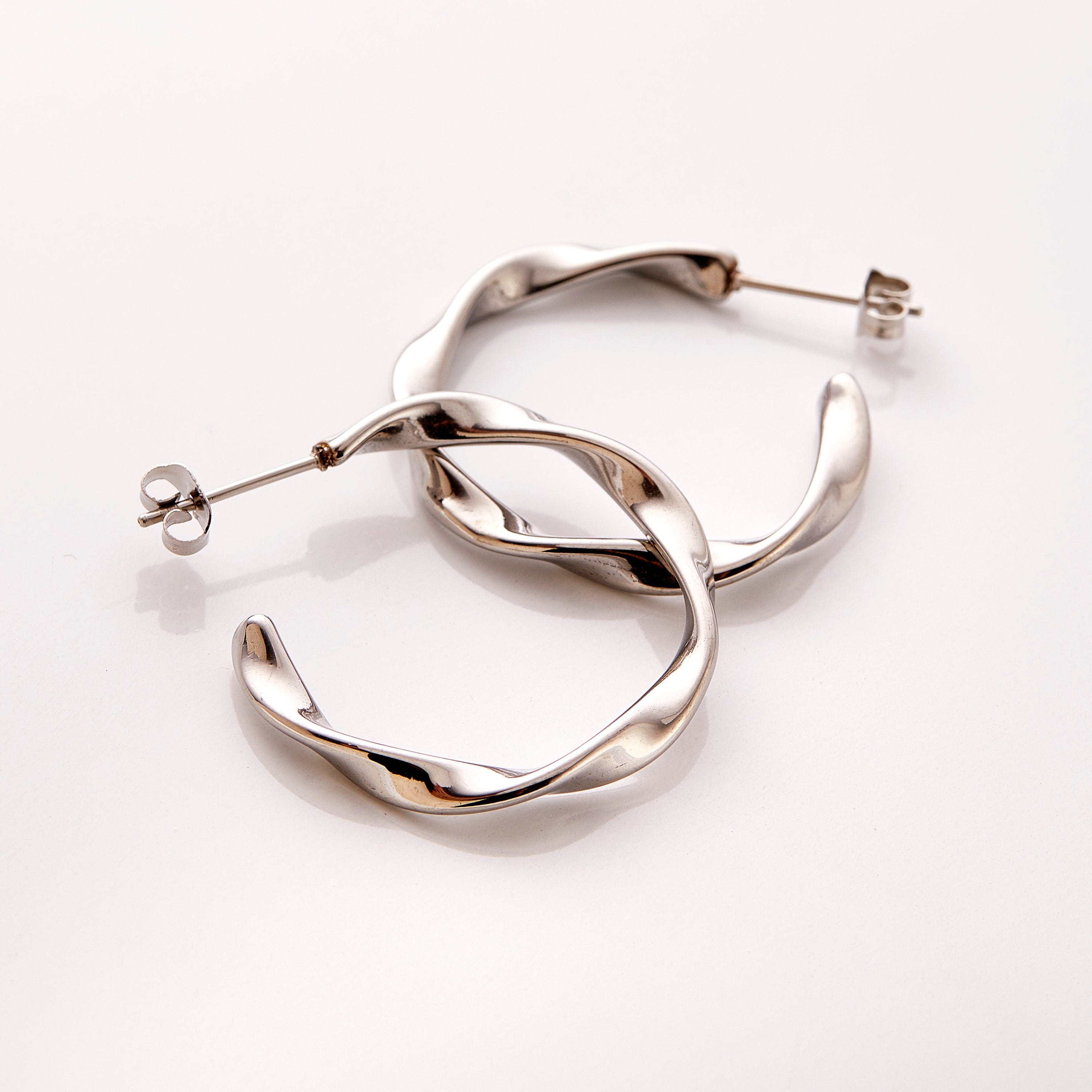 The Silver Ripple Hoop Earrings - Nominal against a white background.